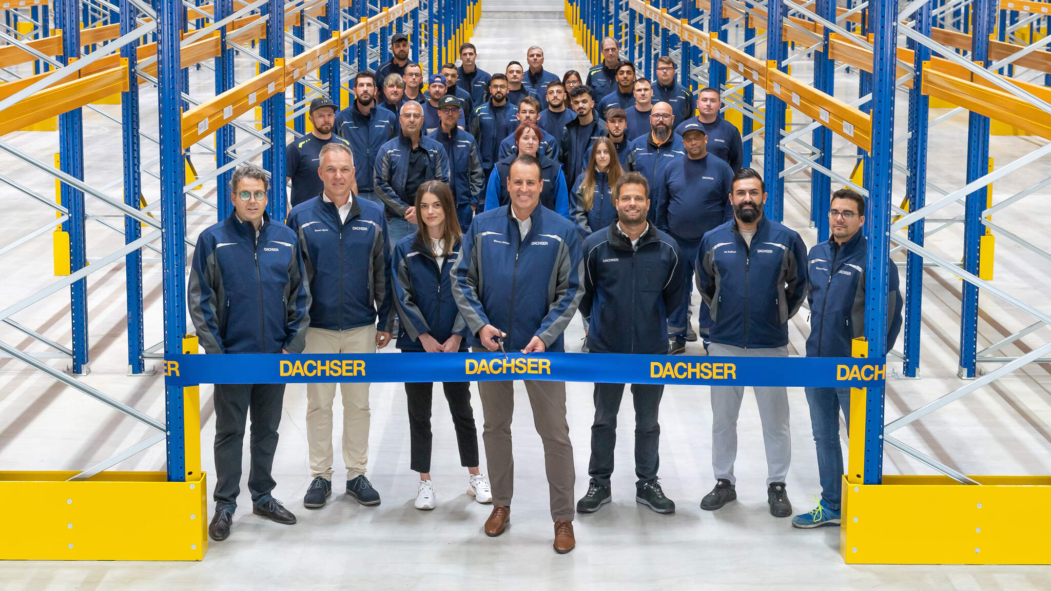 Marco Geiger (front row, center) with the small management circle (front row) and employees of DACHSER in Rottenburg am Neckar at the opening of the additional warehouse. Photo: DACHSER/Simon Jung